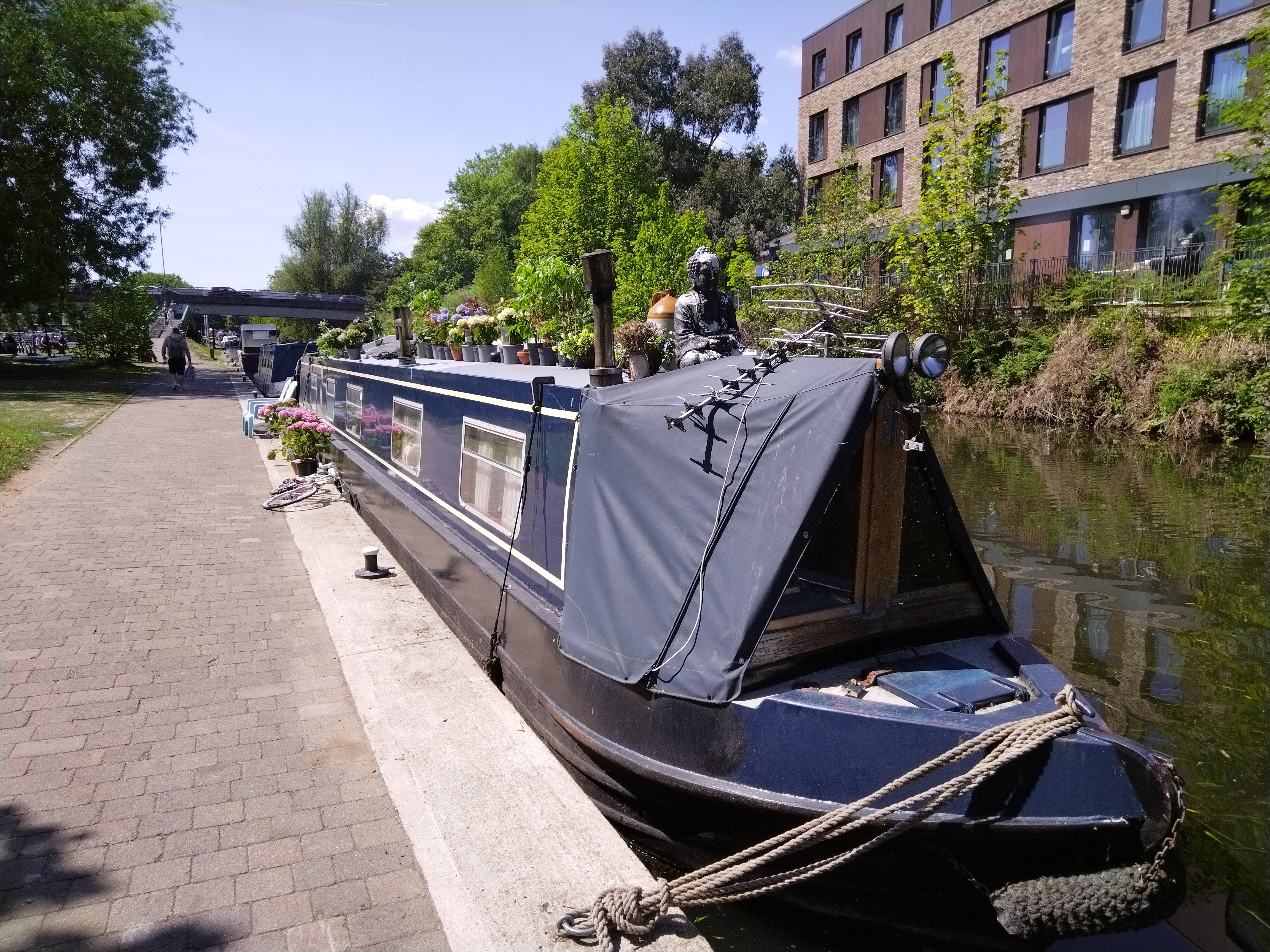 dark blue canal boat moored in Nottingham with a blue sky